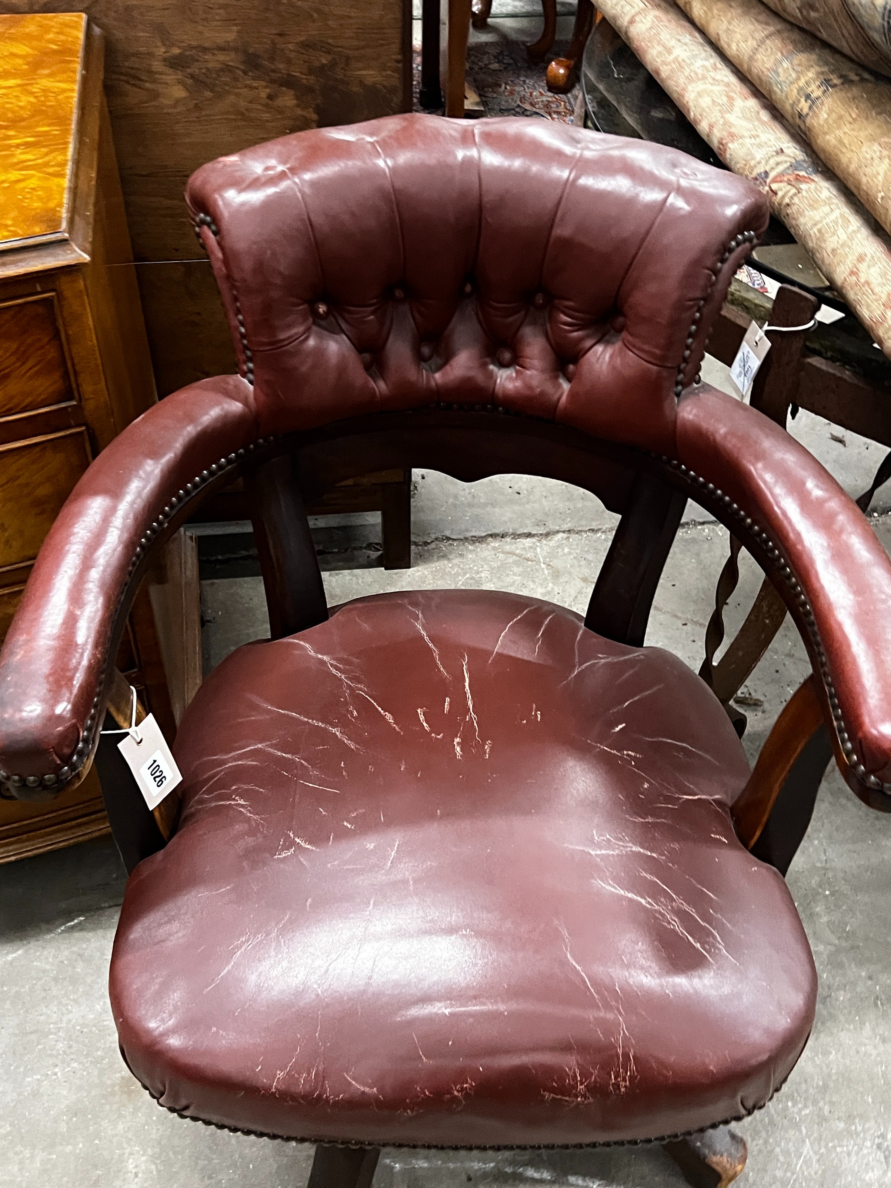 An early 20th century burgundy leather tub framed swivel desk chair, width 61cm, depth 50cm, height 89cm
